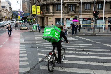 Bisikletli bir Bolt gıda kuryesi Romanya 'nın Bükreş kentinde yiyecek dağıtıyor