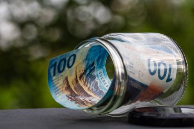 İsviçre frangı CHF banknotu cam kavanozda para biriktiriyor. Tüketim ve ekonomi. İş, bahşiş, finans, tasarruf, bankacılık ve insan kavramı