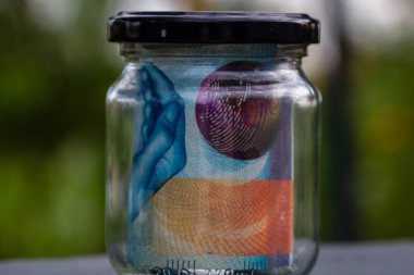 İsviçre frangı CHF banknotu cam kavanozda para biriktiriyor. Tüketim ve ekonomi. İş, bahşiş, finans, tasarruf, bankacılık ve insan kavramı