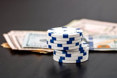 Siyah arka planda parası olan poker fişleri yığını, Amerikan Doları para birimi