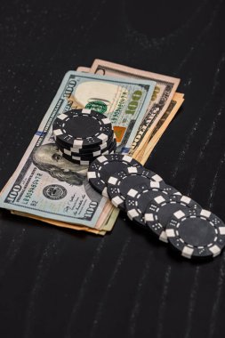 Siyah arka planda parası olan poker fişleri yığını, Amerikan Doları para birimi