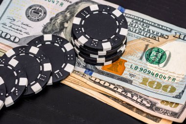 Siyah arka planda parası olan poker fişleri yığını, Amerikan Doları para birimi
