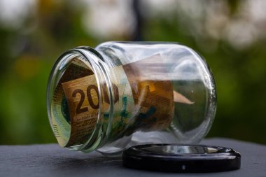 İsviçre frangı CHF banknotu cam kavanozda para biriktiriyor. Tüketim ve ekonomi. İş, bahşiş, finans, tasarruf, bankacılık ve insan kavramı