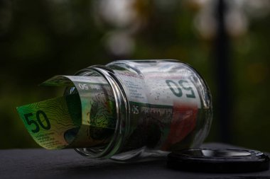 İsviçre frangı CHF banknotu cam kavanozda para biriktiriyor. Tüketim ve ekonomi. İş, bahşiş, finans, tasarruf, bankacılık ve insan kavramı