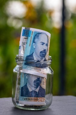 Bulgar LEVA banknotu cam kavanozda para biriktiriyor. Tüketim ve ekonomi. İş, bahşiş, finans, tasarruf, bankacılık ve insan kavramı