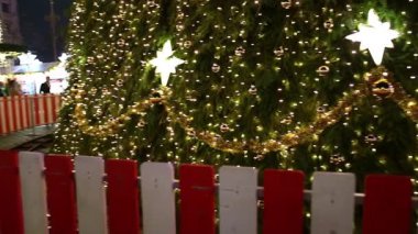 Gece Bükreş Noel pazarında süslü ağaçlar, renkli dönme dolaplar ve tatil pazarının tadını çıkaran insanlar