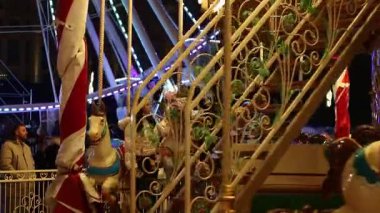 Gece Bükreş Noel pazarında süslü ağaçlar, renkli dönme dolaplar ve tatil pazarının tadını çıkaran insanlar