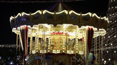 Gece Bükreş Noel pazarında süslü ağaçlar, renkli dönme dolaplar ve tatil pazarının tadını çıkaran insanlar