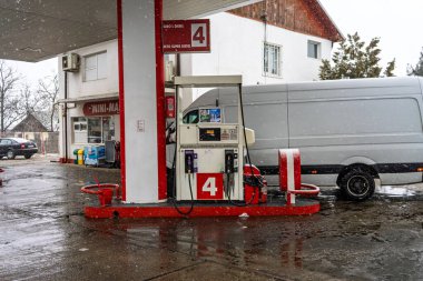 LUKOIL benzin istasyonunun dışı. Benzin pompaları ve arabalar kar yağarken yakıt ikmali yapıyorlar.
