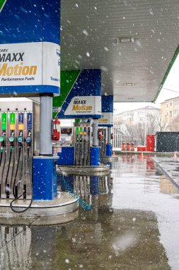 Bir OMV benzin istasyonunun dışı. Benzin pompaları ve arabalar kar yağarken yakıt ikmali yapıyorlar.