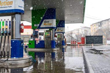 Bir OMV benzin istasyonunun dışı. Benzin pompaları ve arabalar kar yağarken yakıt ikmali yapıyorlar.