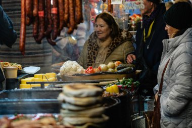 Bükreş Noel Pazarı 'nda geleneksel Romen yemekleri. Lezzetli sokak yemekleri ve şenlikli tatlar.