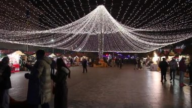 Targoviste Noel Pazarı. Şehir meydanında süslü ağaçlar ve şenlikli ışıklar var. İnsanlar Noel Pazarı 'nı seviyor
