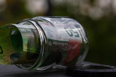 İsviçre frangı CHF banknotu cam kavanozda para biriktiriyor. Tüketim ve ekonomi. İş, bahşiş, finans, tasarruf, bankacılık ve insan kavramı