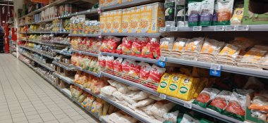 Süpermarket koridoru rafları dolduran ürünlerle dolu. Carrefour süpermarketi, Avrupa 'nın en büyük süpermarket zincirlerinden biri.