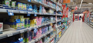 Süpermarket koridoru rafları dolduran ürünlerle dolu. Carrefour süpermarketi, Avrupa 'nın en büyük süpermarket zincirlerinden biri.