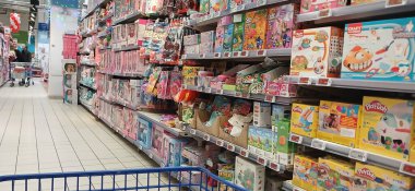 Süpermarket koridoru rafları dolduran ürünlerle dolu. Carrefour süpermarketi, Avrupa 'nın en büyük süpermarket zincirlerinden biri.