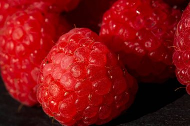 Taze iştah açıcı olgun ahududu. Detaylı bir makro fotoğrafta doku ve canlı kırmızı ahududu rengini gösteriyor.