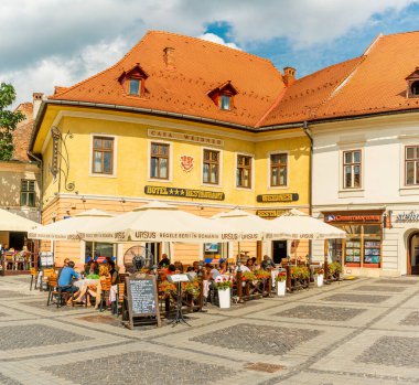 People wandering through the medieval streets of old town Sibiu Romania during summer travel