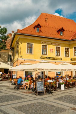 People wandering through the medieval streets of old town Sibiu Romania during summer travel