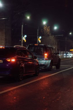 Gece Bükreş 'teki şehir sokak sahnesinde otomobil ışıkları ve boş şehir yolları yer alıyor