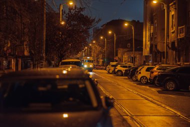 Gece Bükreş 'teki şehir sokak sahnesinde otomobil ışıkları ve boş şehir yolları yer alıyor