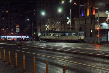 Gece Bükreş 'teki şehir sokak sahnesinde otomobil ışıkları ve boş şehir yolları yer alıyor
