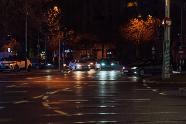 Gece Bükreş 'teki şehir sokak sahnesinde otomobil ışıkları ve boş şehir yolları yer alıyor