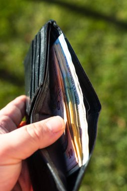 Romen LEI banknotlarıyla el ele tutuşan adamın elinde kağıt doku ve Rumen LEI para birimi sembolleri görülüyor