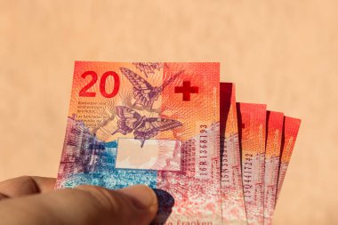 İsviçre frangı para banknotlarını tutan adam, İsviçre CHF para biriminin kağıt dokusu ve sembollerini gösteriyor