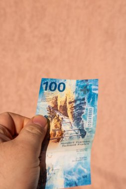 İsviçre frangı para banknotlarını tutan adam, İsviçre CHF para biriminin kağıt dokusu ve sembollerini gösteriyor