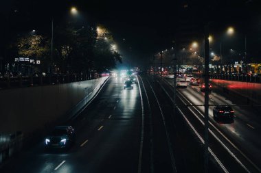 Gece Bükreş 'te Victoria Meydanı' ndaki ana bulvarda araba trafiği