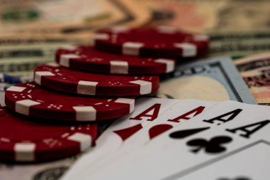 Amerikan dolarları üzerine yığılmış poker fişleri ve kumarhaneyi temsil eden kâğıtlar ve riskler