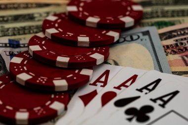 Amerikan dolarları üzerine yığılmış poker fişleri ve kumarhaneyi temsil eden kâğıtlar ve riskler