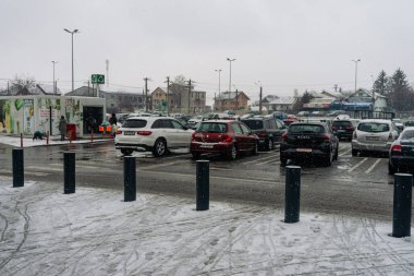 Kış boyunca Bükreş 'in yoğun bir caddesinde yoğun trafikte arabaları kar kapladı