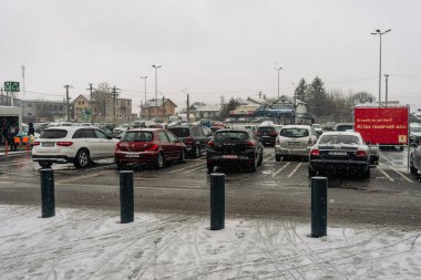 Kış boyunca Bükreş 'in yoğun bir caddesinde yoğun trafikte arabaları kar kapladı