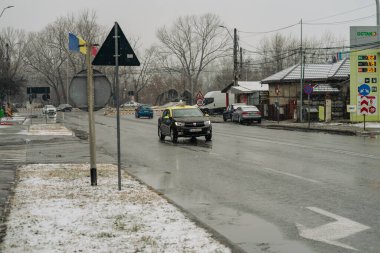 Kış boyunca Bükreş 'in yoğun bir caddesinde yoğun trafikte arabaları kar kapladı