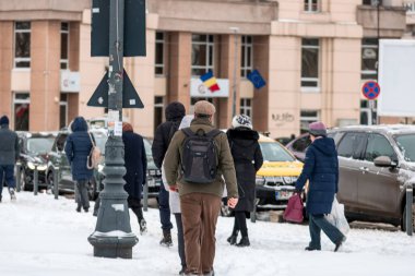 Bükreş 'te karlı bir yolda yürüyen insanların olduğu kentsel kış sahnesi