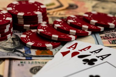 Amerikan dolarları üzerine yığılmış poker fişleri ve kumarhaneyi temsil eden kâğıtlar ve riskler