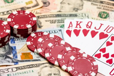 Amerikan dolarları üzerine yığılmış poker fişleri ve kumarhaneyi temsil eden kâğıtlar ve riskler