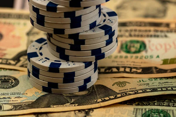 Amerikan dolarları üzerine yığılmış poker fişleri ve kumarhaneyi temsil eden kâğıtlar ve riskler