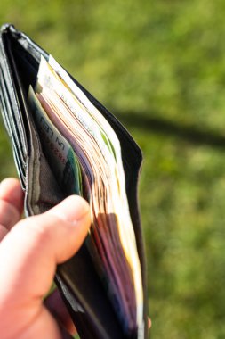 Romen LEI banknotlarıyla el ele tutuşan adamın elinde kağıt doku ve Rumen LEI para birimi sembolleri görülüyor