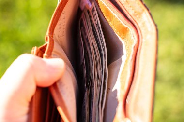 Amerikan dolarının kağıt dokusu ve sembollerini gösteren ABD Doları banknotlarıyla el ele tutuşan adam.