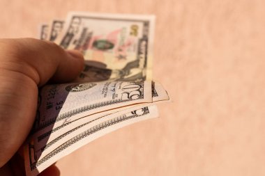 ABD Doları banknotlarıyla el ele tutuşan ve kağıt doku ve Amerikan Amerikan para biriminin sembollerini gösteren bir adam.