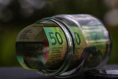İsviçre frangı CHF banknotu cam kavanozda para biriktiriyor. Tüketim ve ekonomi. İş, bahşiş, finans, tasarruf, bankacılık ve insan kavramı