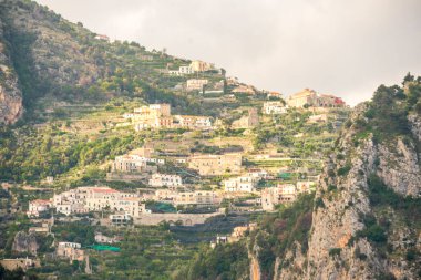 Amalfi Sahili 'nin kayalıklarında ana katedrali ve renkli eski binaları bulunan tarihi Amalfi kasabası.