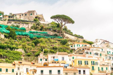 Amalfi Sahili 'nin kayalıklarında ana katedrali ve renkli eski binaları bulunan tarihi Amalfi kasabası.
