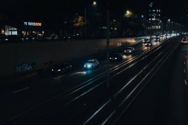 Gece Bükreş 'te Victoria Meydanı' ndaki ana bulvarda araba trafiği