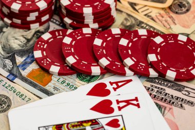 Amerikan dolarları üzerine yığılmış poker fişleri ve kumarhaneyi temsil eden kâğıtlar ve riskler