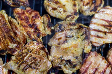 Domuz bifteği ve sosis sıcak ızgarada pişiyor. Açık hava pikniği için duman ve alevlerle.